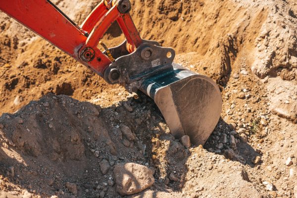 Excavator shovel digging on dirt on a construction site