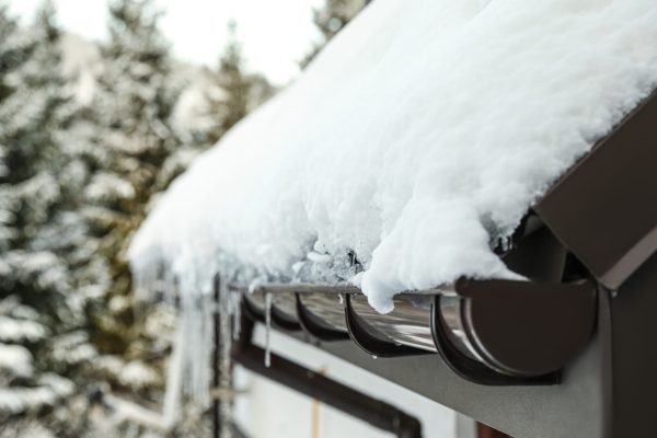 House roof covered with snow outdoors, closeup. Winter vacation
